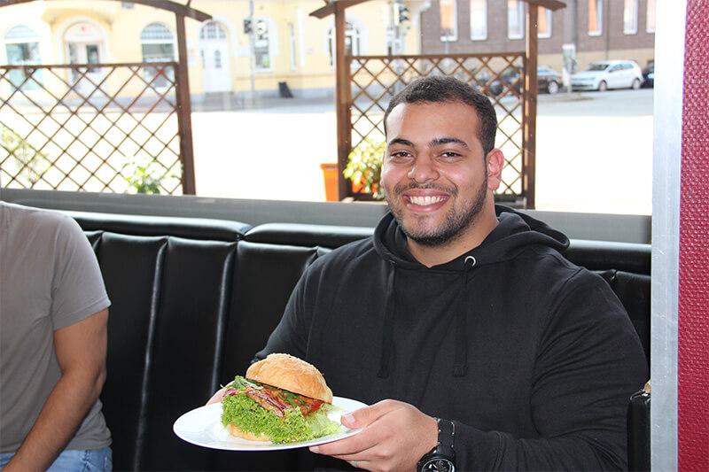 Mann isst Burger in Kiel